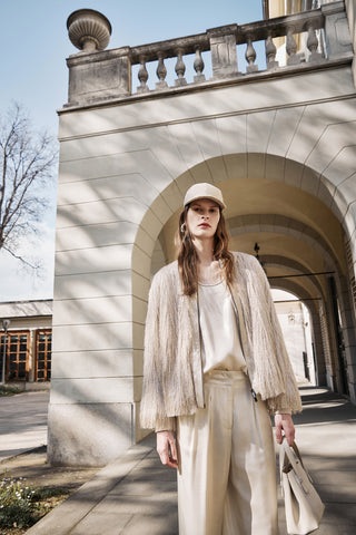 woman with fil coupé bomber and satin top and pants, all beige color